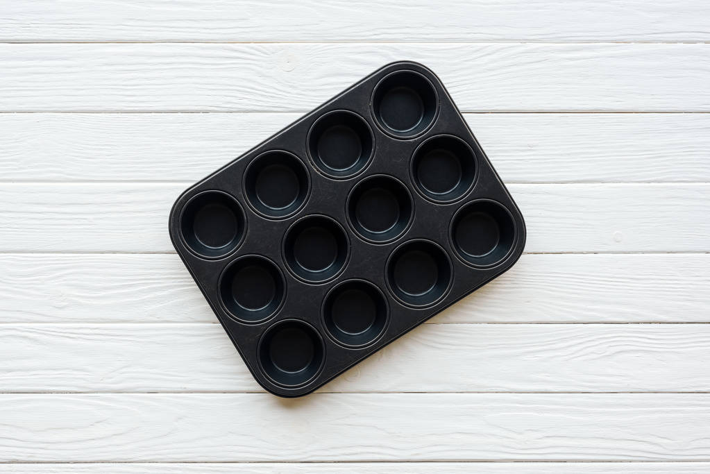 top view of metal muffin tray on white wooden table - Photo, Image