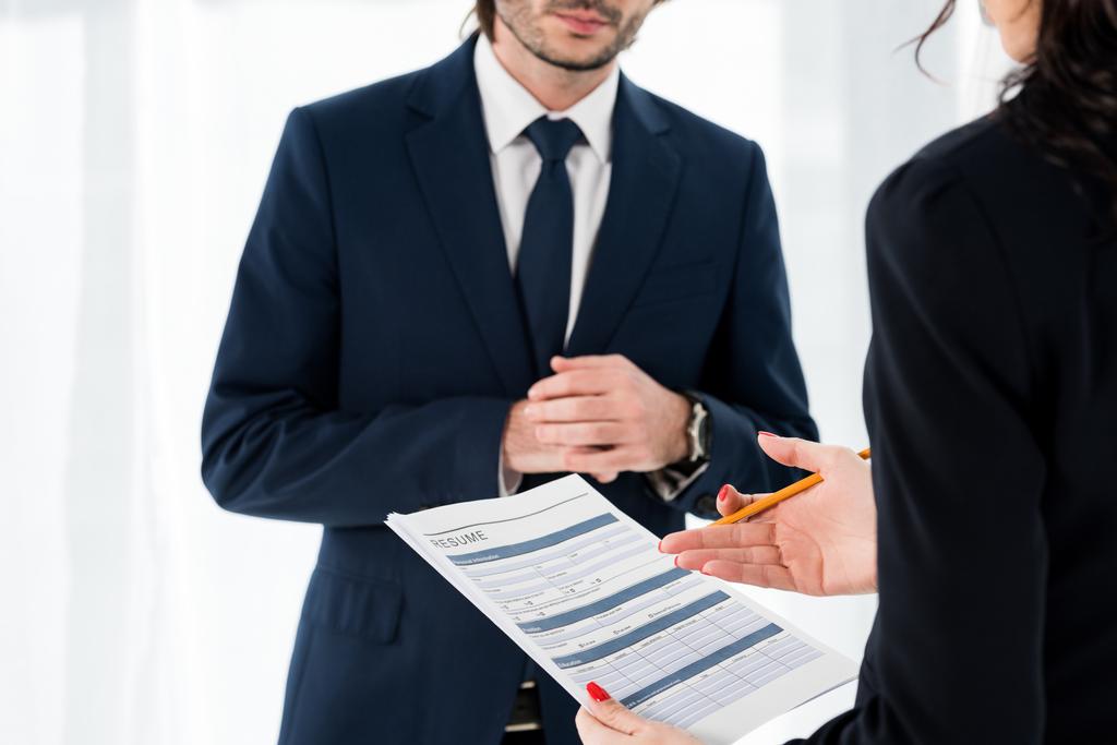cropped view of woman holding resume and gesturing near man  - Photo, Image