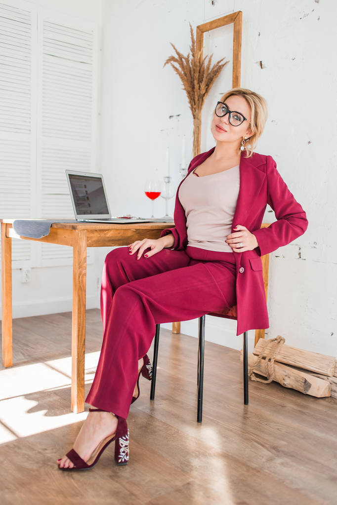 Mooie slimme zakelijke vrouw zittend aan tafel op Workstation met laptop - Foto, afbeelding