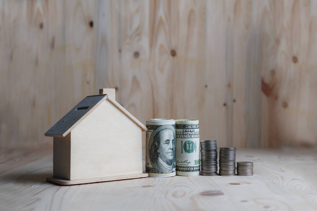 Puinen talo säästöpossu dollarin rahaa ja kolikon puinen välilehti
 - Valokuva, kuva