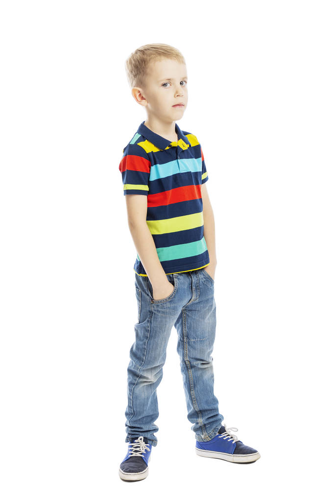 Stojący chłopiec w pełnym wzroście w dżinsy i jasny T-shirt. Izolowane na białym tle.  - Zdjęcie, obraz
