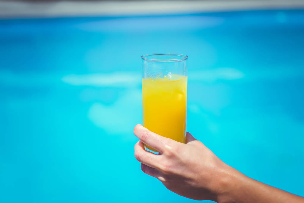 Glas frischer Orangen- oder Ananassaft am Pool - Foto, Bild