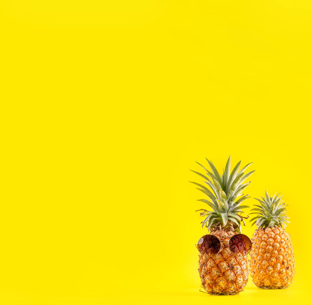 Ananas creativo guardando in su con occhiali da sole e guscio isolato su sfondo giallo, modello di progettazione idea spiaggia vacanza estiva, copiare lo spazio da vicino
 - Foto, immagini