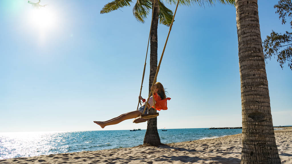 Concepto de vacaciones. Mujer joven columpiándose en un columpio de playa. Mujeres viajeras felices en la playa de Phu Quoc
 - Foto, imagen