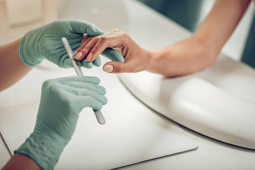 Профессиональный мастер ногтей носить защитные резиновые перчатки
 - Фото, изображение