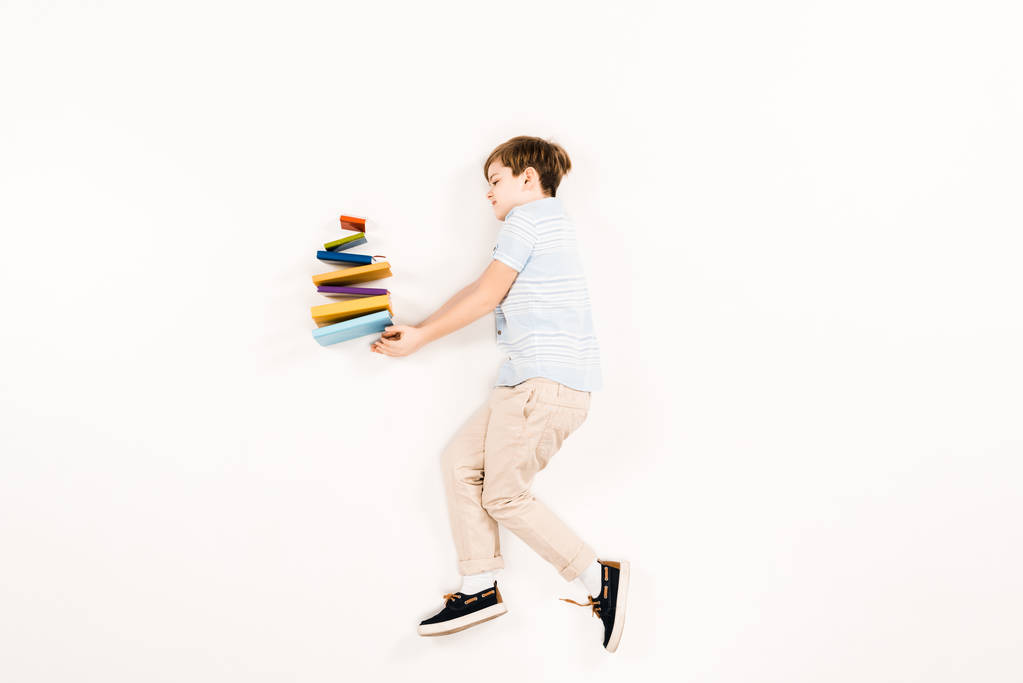 vue du haut de mignon enfant tenant des livres colorés sur blanc
 - Photo, image