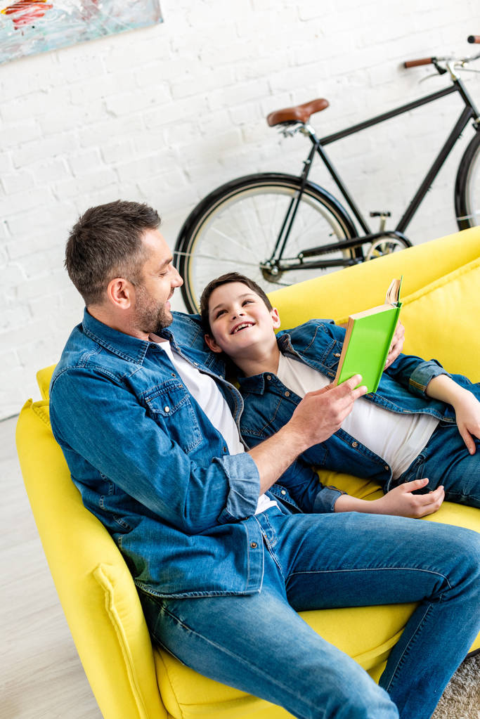 evde kanepede denim okuma kitabı mutlu baba ve oğlu - Fotoğraf, Görsel
