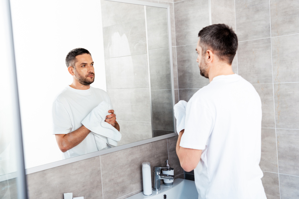 bel homme essuyant les mains avec une serviette dans la salle de bain le matin
 - Photo, image