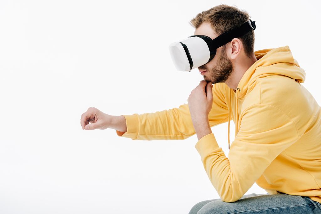 young man imitating writing while using virtual reality headset isolated on white - Photo, Image