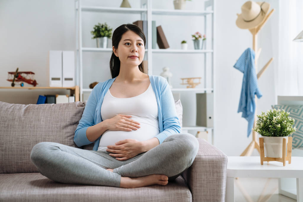 W ciąży szczęśliwy uśmiechnięta kobieta siedzi na kanapie - Zdjęcie, obraz