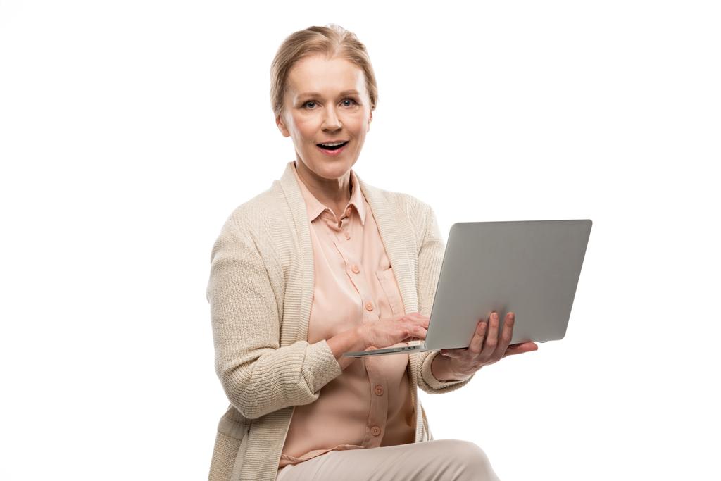 middelbare leeftijd vrouw met behulp van laptop en kijken naar camera geïsoleerd op wit - Foto, afbeelding