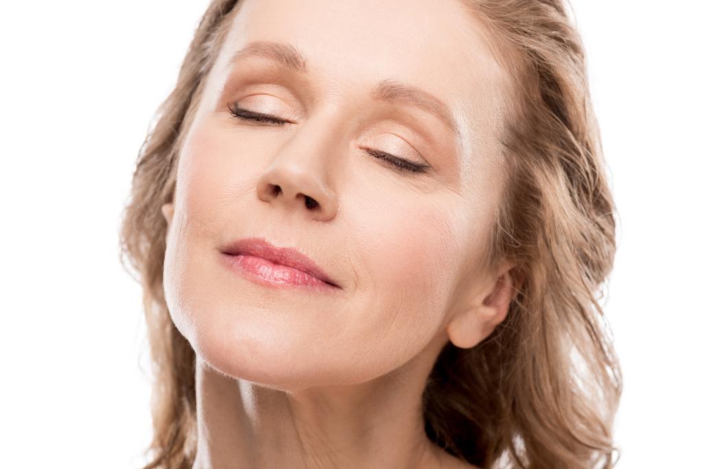 mooie middelste leeftijd vrouw met schoon gezicht en ogen gesloten geïsoleerd op wit  - Foto, afbeelding