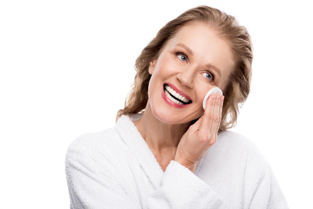 bella donna matura pulire il viso con batuffolo di cotone isolato su bianco
 - Foto, immagini