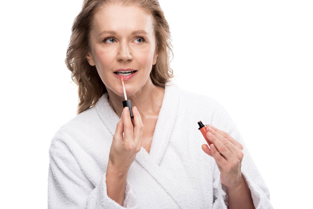 atraente mulher madura aplicando labial brilho isolado no branco
  - Foto, Imagem