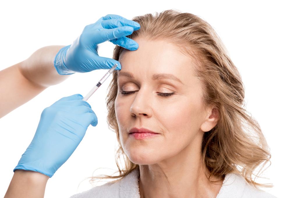 médico dando injeção de beleza para bela mulher de meia-idade Isolado em branco
 - Foto, Imagem