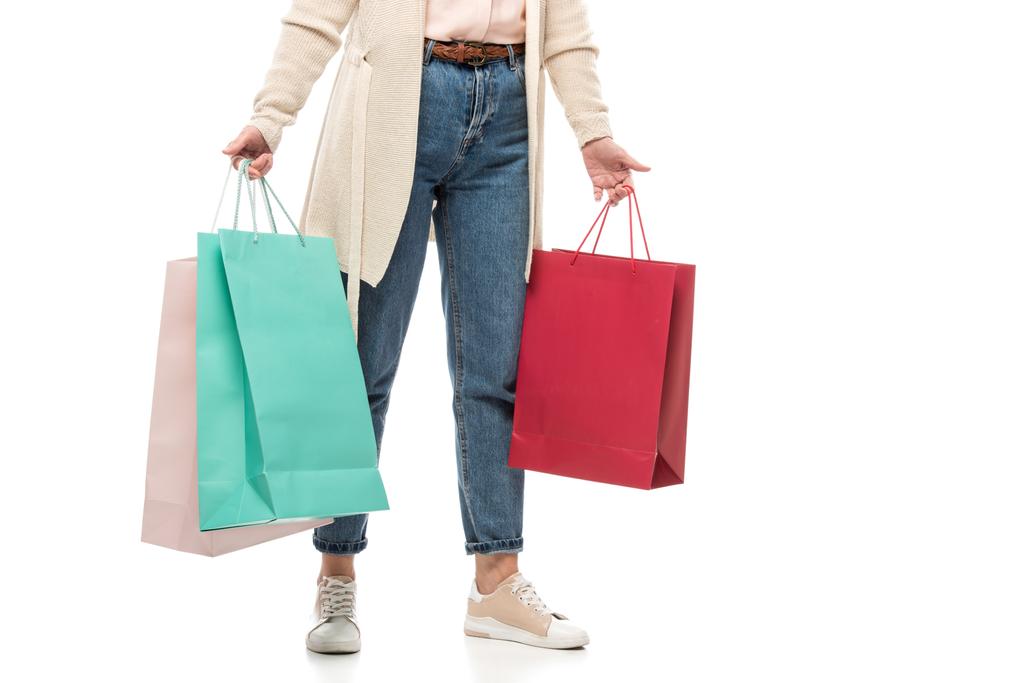 Περικομμένη θέα της μεσήλικες γυναίκα με σακούλες για ψώνια στο λευκό - Φωτογραφία, εικόνα
