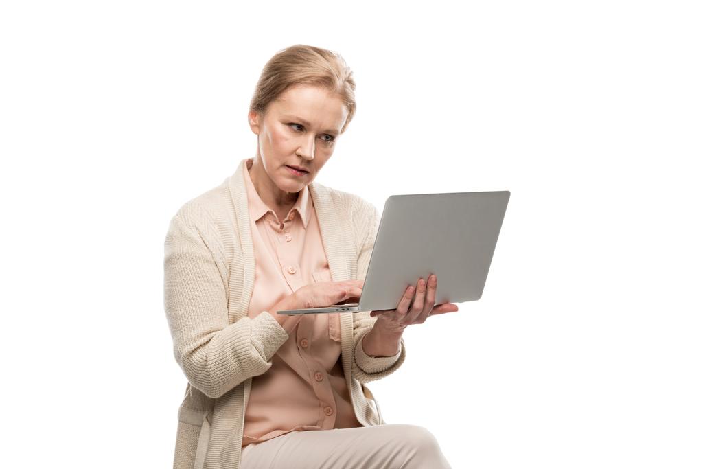 Verwirrte Frau mittleren Alters mit Laptop isoliert auf weiß - Foto, Bild