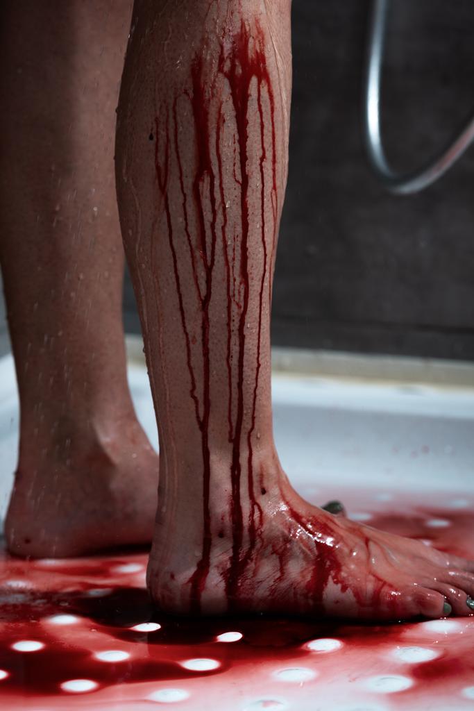 gedeeltelijke weergave van blootsvoets bloeden vrouw in de badkamer  - Foto, afbeelding