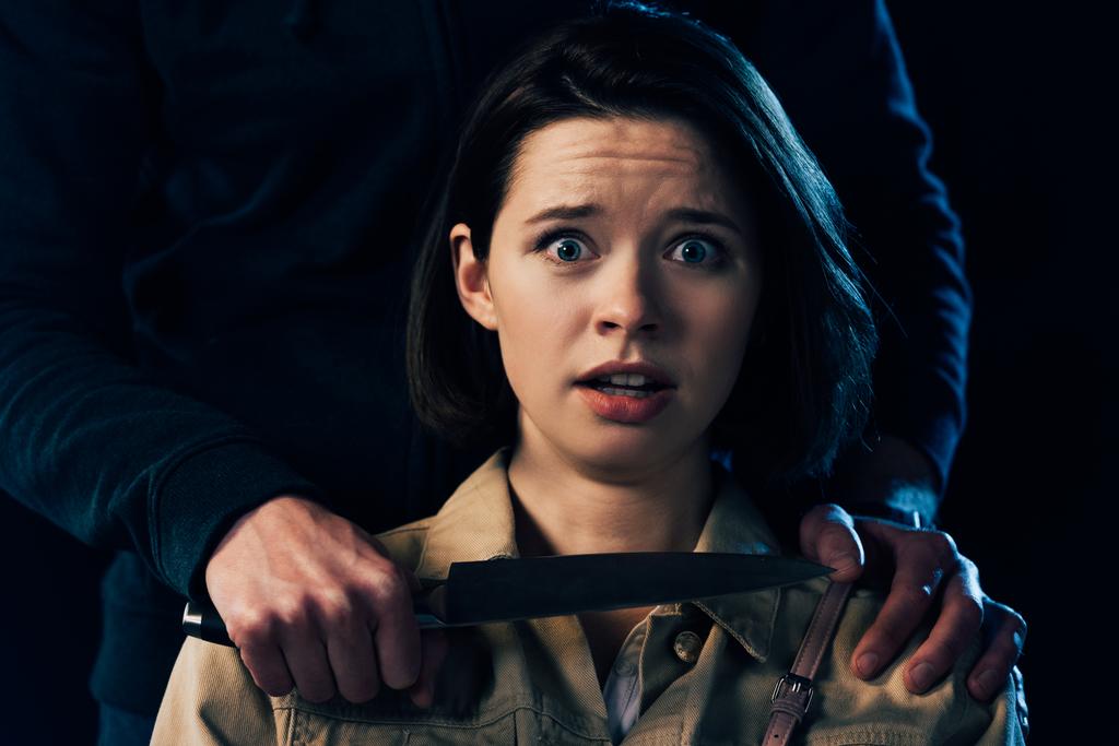 частичное представление женщины, нападающей на преступника с ножом, изолированным на черном
 - Фото, изображение