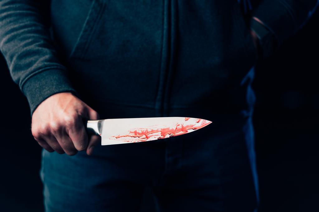 vista recortada del asesino sosteniendo cuchillo aislado en negro
 - Foto, imagen