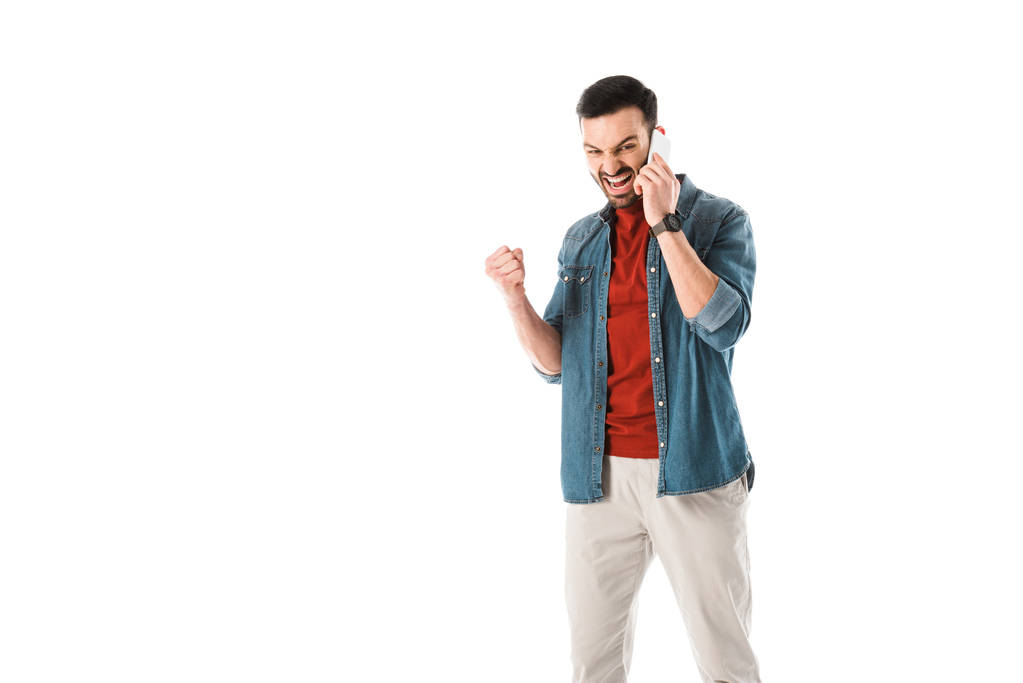 irritado homem brigando e mostrando punho enquanto fala no smartphone isolado no branco
 - Foto, Imagem