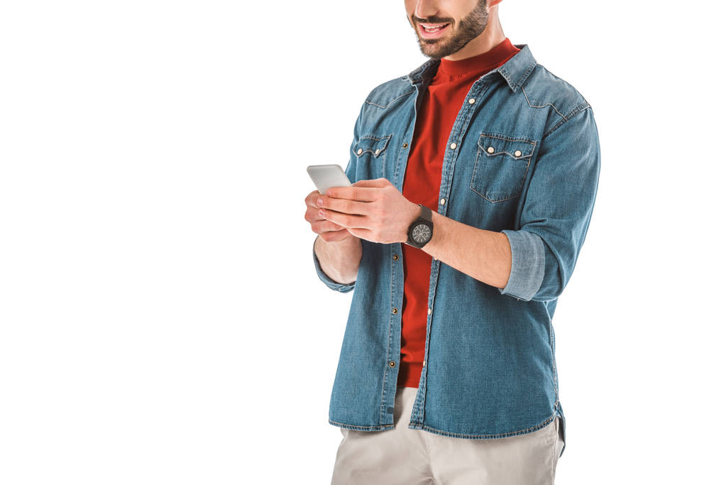 vista parcial del hombre adulto en camisa de mezclilla usando teléfono inteligente aislado en blanco
 - Foto, imagen