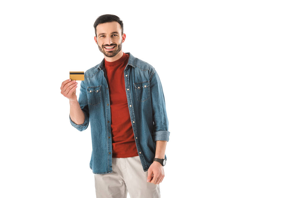 sonriente hombre sosteniendo la tarjeta de crédito mientras mira la cámara aislada en blanco
 - Foto, Imagen