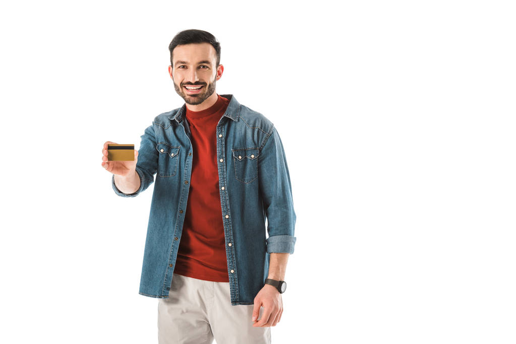 cheerful man holding credit card while looking at camera isolated on white - Photo, Image