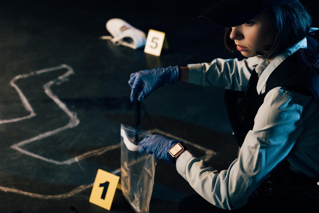 Investigador de uniforme a recolher provas no local do crime
 - Foto, Imagem