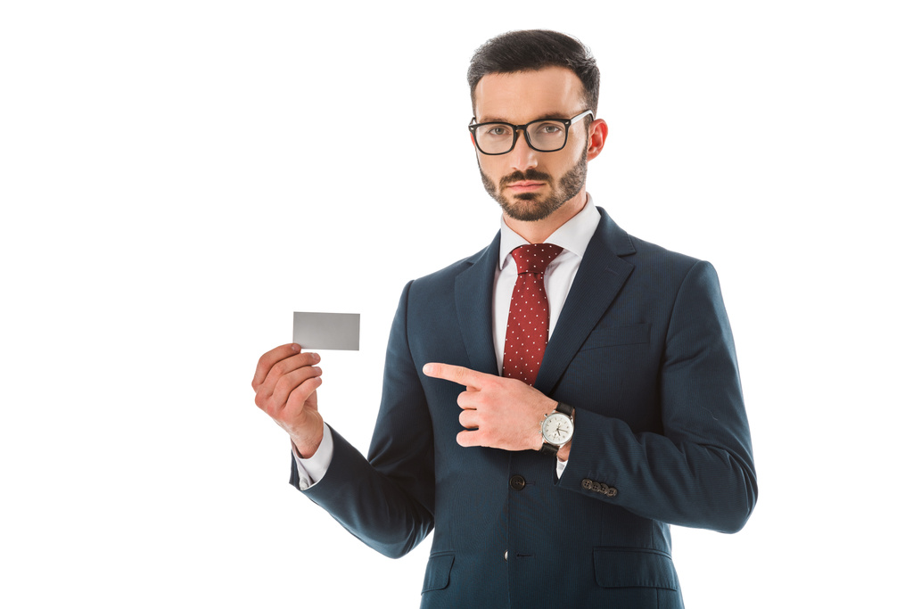 seriöser Geschäftsmann zeigt mit dem Finger auf leere Visitenkarte und blickt isoliert auf weiße Kamera - Foto, Bild