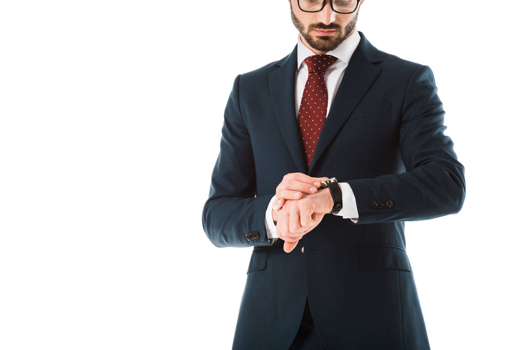 περικομμένη θέα του επιχειρηματία με μαύρο κοστούμι κοιτάζοντας το ρολόι απομονώνεται σε λευκό - Φωτογραφία, εικόνα