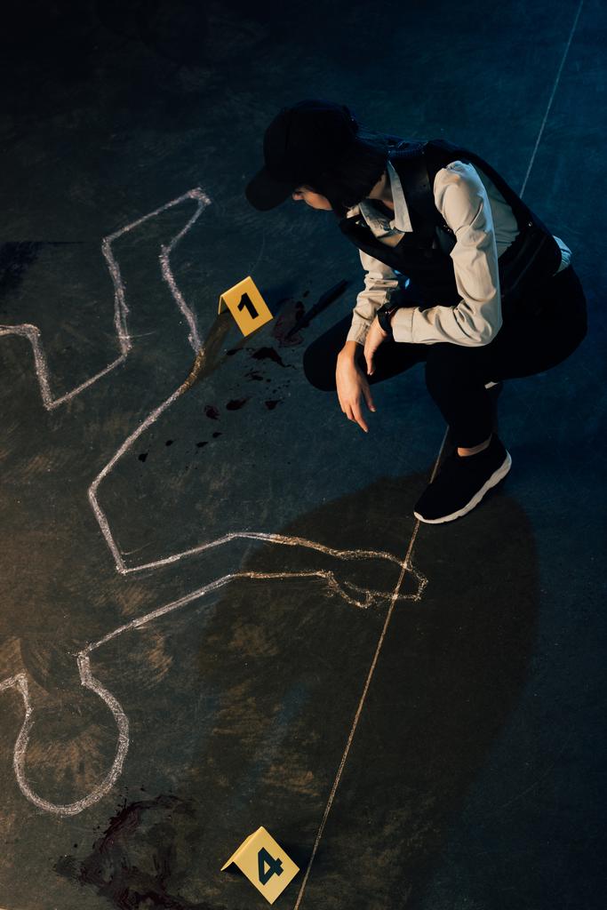 Widok ogólny detektywa w pobliżu konturu kredą i markerów dowodów na scenie zbrodni - Zdjęcie, obraz
