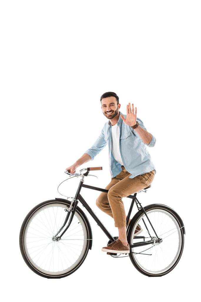 handsome cheerful man riding bicycle and showing hello gesture at camera isolated on white - Photo, Image