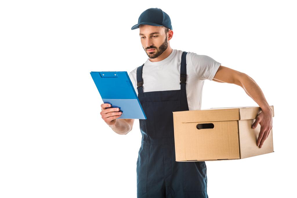 atento hombre de entrega guapo sosteniendo caja de cartón y mirando portapapeles aislado en blanco
 - Foto, imagen