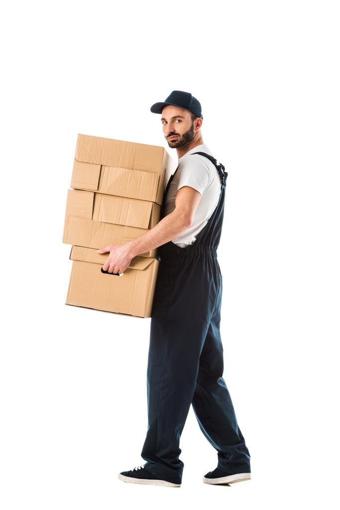 zelfverzekerde levering man vervoert kartonnen dozen en kijken naar camera geïsoleerd op wit - Foto, afbeelding