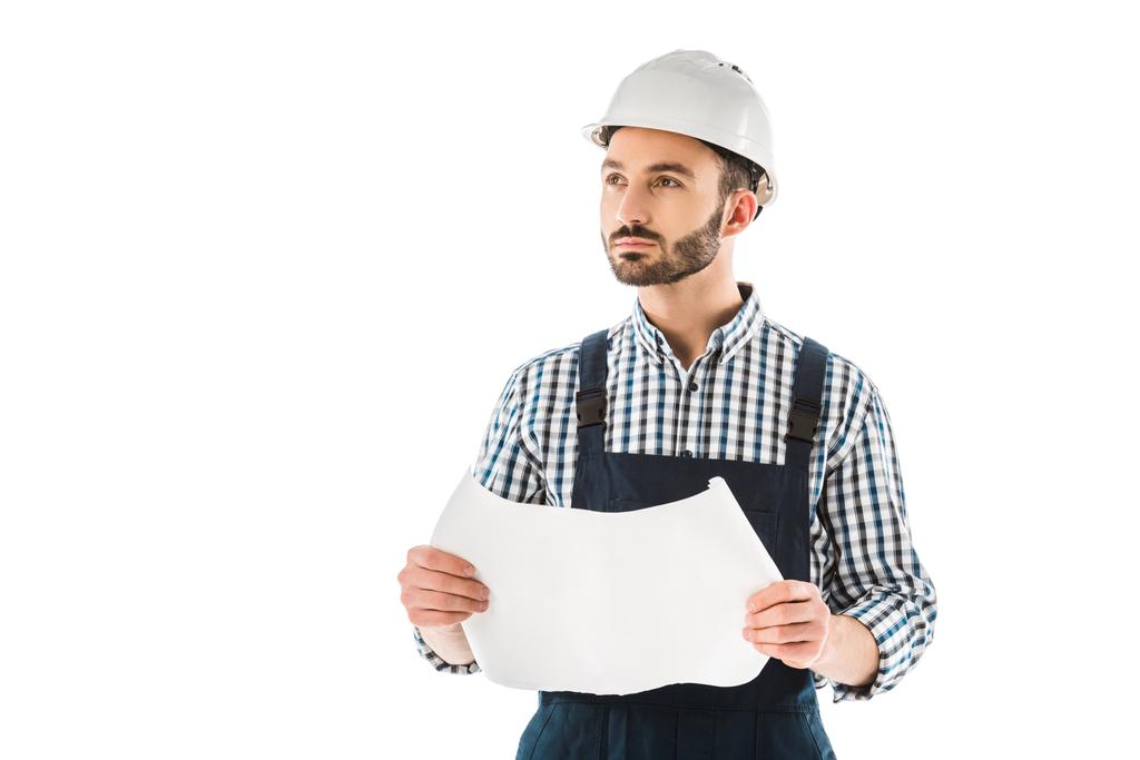 trabalhador de construção pensativo segurando plano de construção e olhando para cima isolado no branco
 - Foto, Imagem