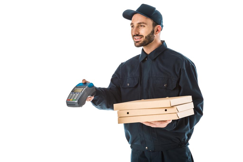 mensajero sonriente en overoles con terminal de pago y cajas de pizza aisladas en blanco
 - Foto, imagen