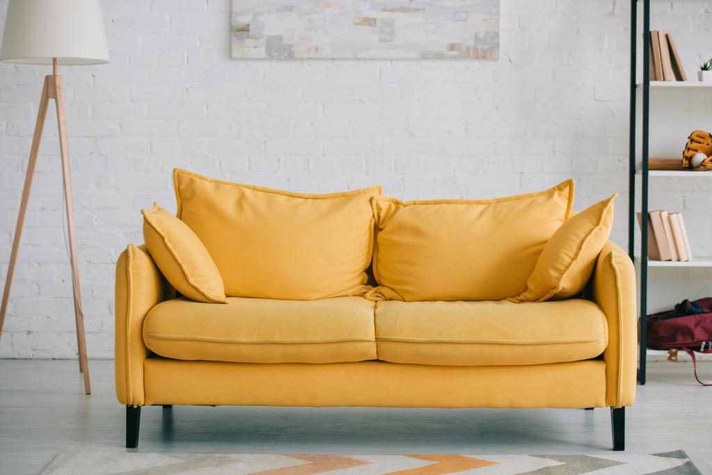 parlak sarı kanepe, zemin lambası ve raf ile geniş, hafif oturma odası - Fotoğraf, Görsel
