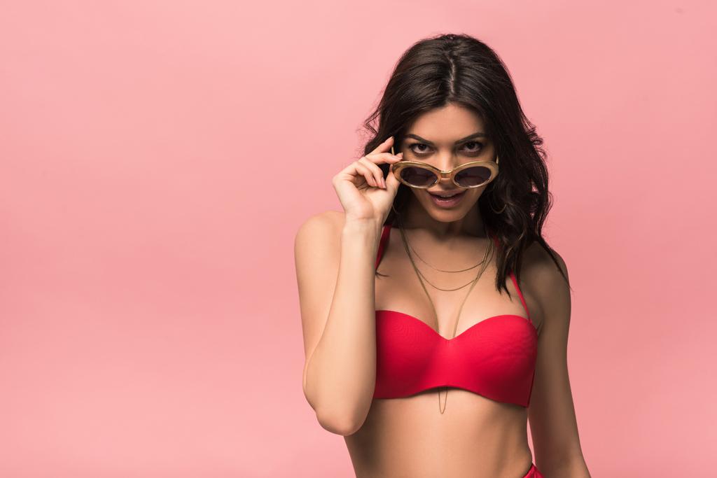 front view of smiling attractive woman in swimsuit and sunglasses isolated on pink - Photo, Image
