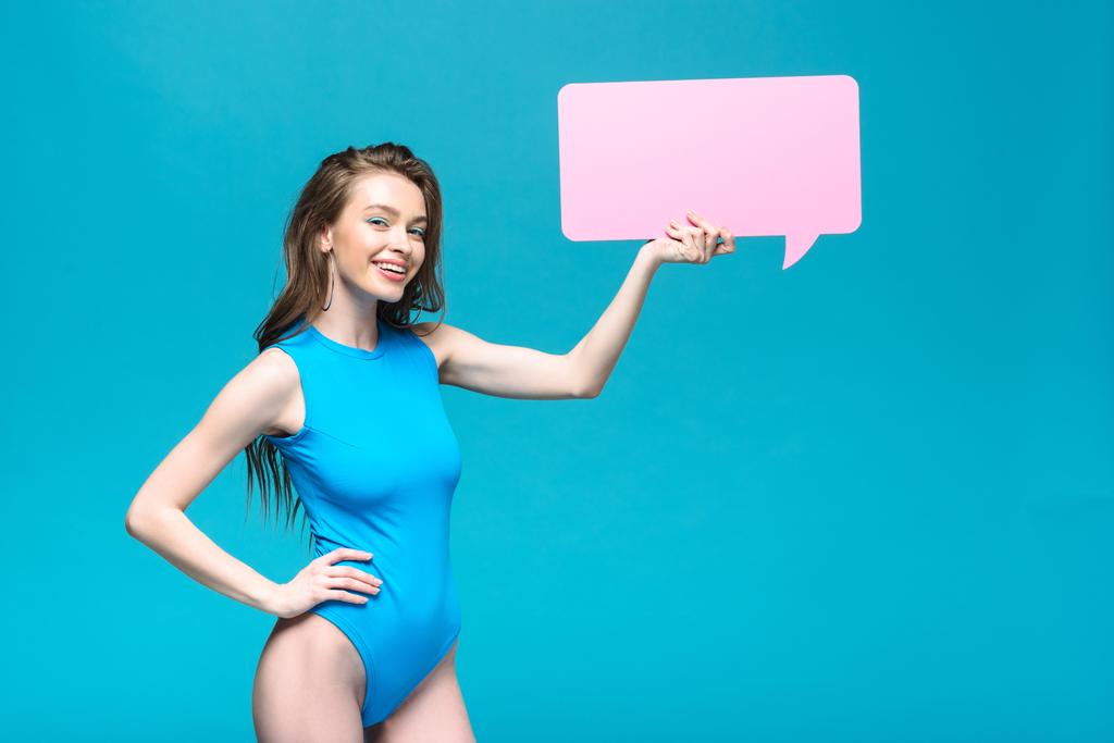 charming girl in swimsuit holding speech bubble isolated on blue - Photo, Image