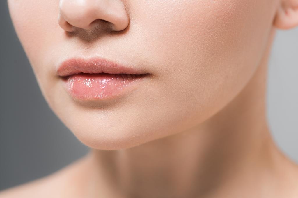 bijgesneden beeld van jonge vrouw met zachte lippen geïsoleerd op grijs  - Foto, afbeelding
