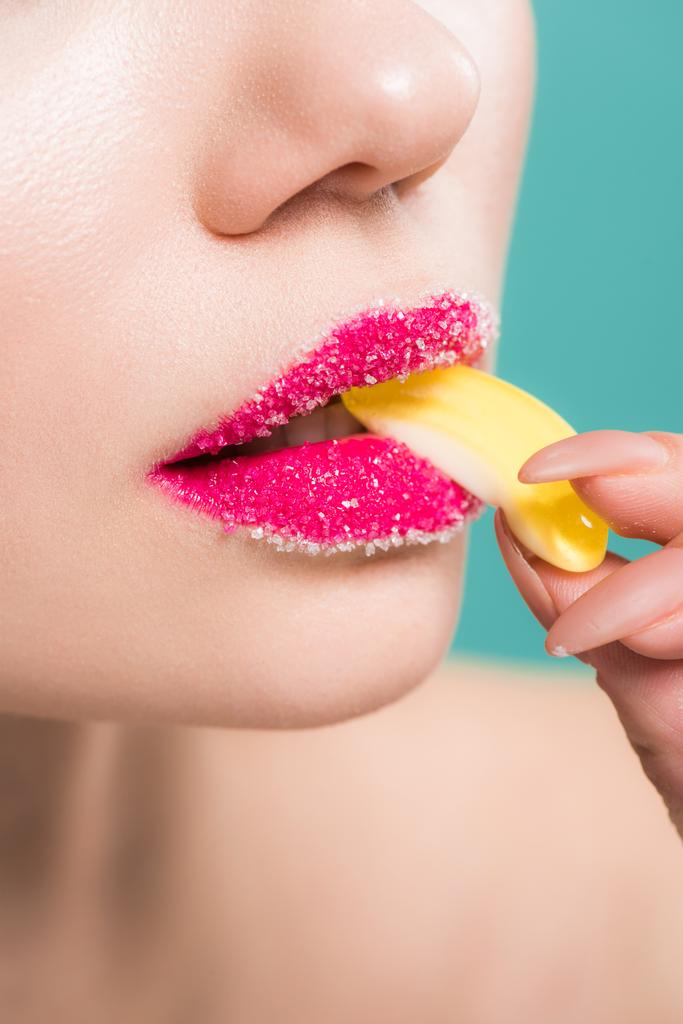 vista ritagliata di donna con zucchero sulle labbra mangiare caramelle gelatina isolato su blu
  - Foto, immagini