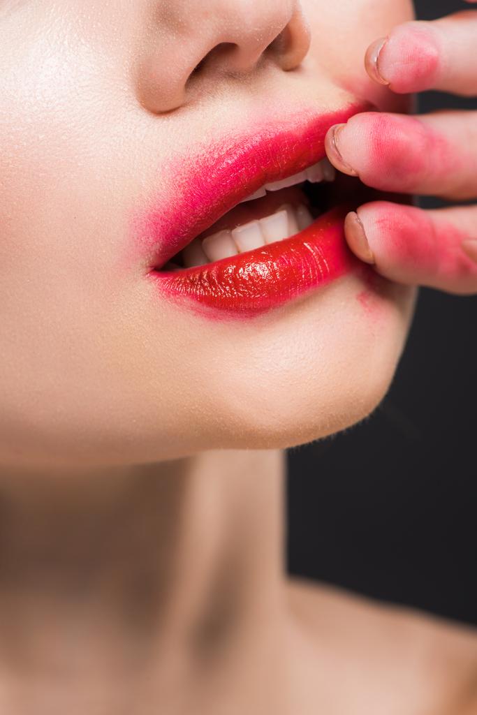 vista cortada de mulher jovem removendo batom vermelho isolado no preto
  - Foto, Imagem
