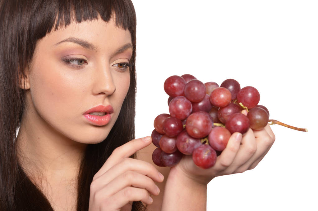 Retrato de una joven posando con uvas aisladas sobre fondo blanco
 - Foto, Imagen