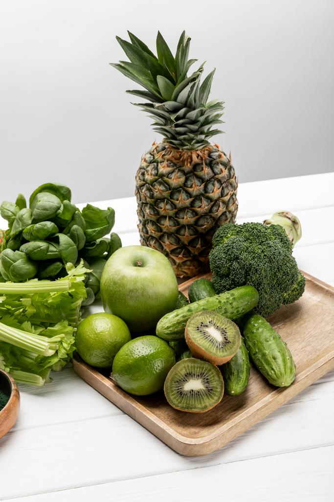 savoureux ananas frais, pommes et chaux près de légumes bio et crus sur gris
  - Photo, image