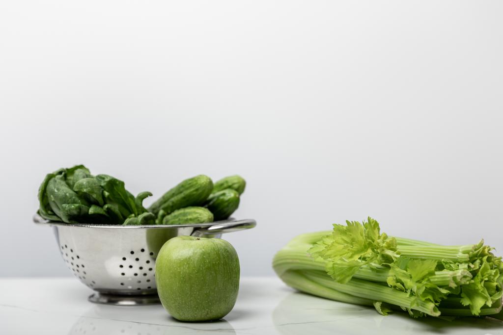 зеленое яблоко рядом со свежими овощами и листьями шпината на белом
  - Фото, изображение