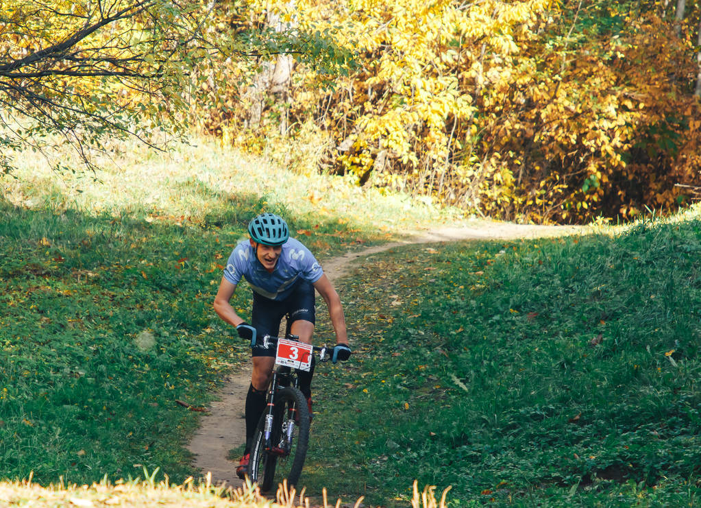 2018. október 14., Minszk, Fehéroroszország.2018 Olympic Cross Country Cup XCO in Medvezhino Kerékpáros az ösvény mentén a gyönyörű őszi erdőben - Fotó, kép
