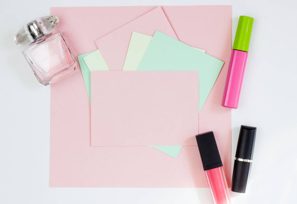 Tarjeta rosa vacía, hoja para escribir. Diseño para añadir etiquetas con perfume y lápiz labial. Vista superior, plano, espacio para copiar
 - Foto, imagen