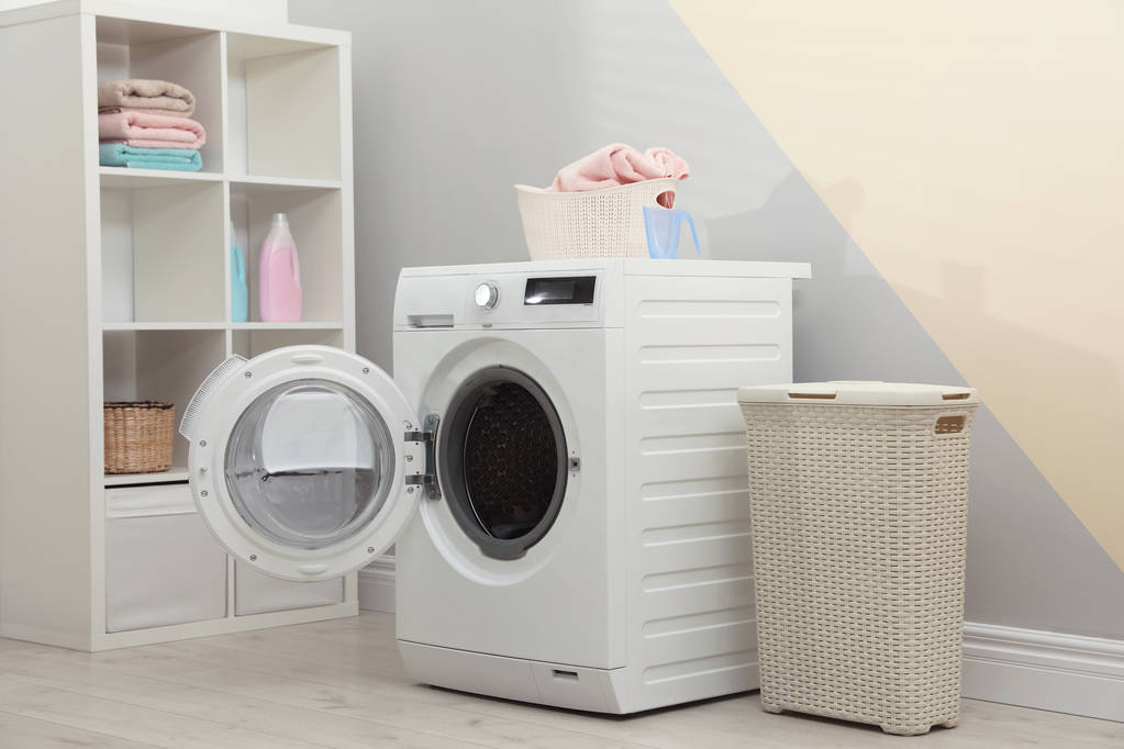 Сучасна пральна машина в інтер'єрі пральної кімнати
 - Фото, зображення