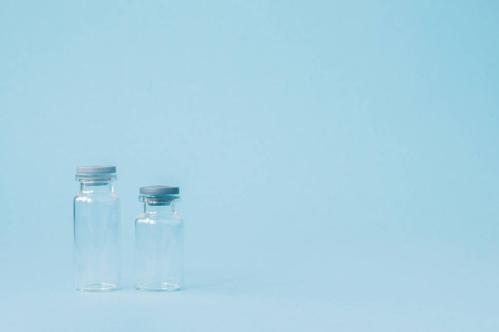 Injectieflacon met geneesmiddel op blauwe achtergrond met Kopieer ruimte. Antibioticum  - Foto, afbeelding